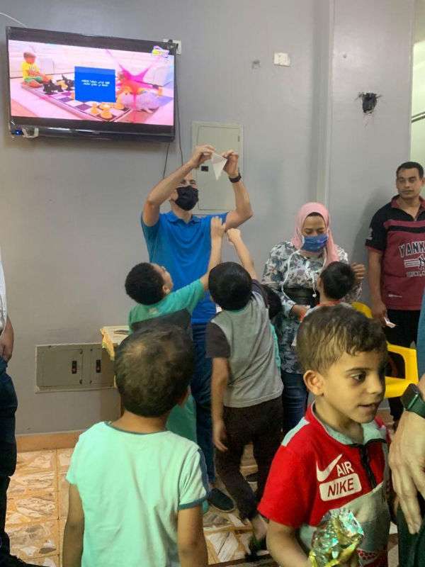 A volunteer shows the orphans some origami birds